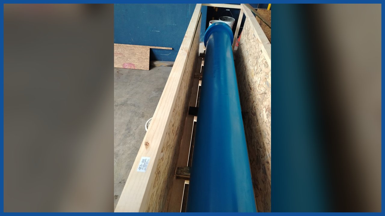 Cilindro hidráulico azul de gran longitud dentro de un cajón de madera