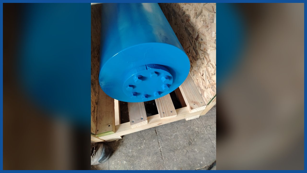Extremo del cilindro hidráulico azul sobre un pallet de madera