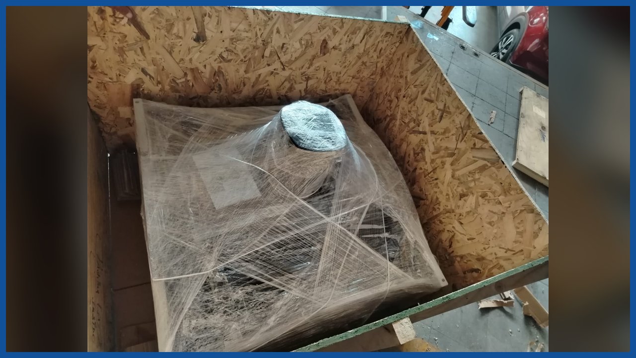 Equipo embalado con film dentro de un cajón de madera abierto