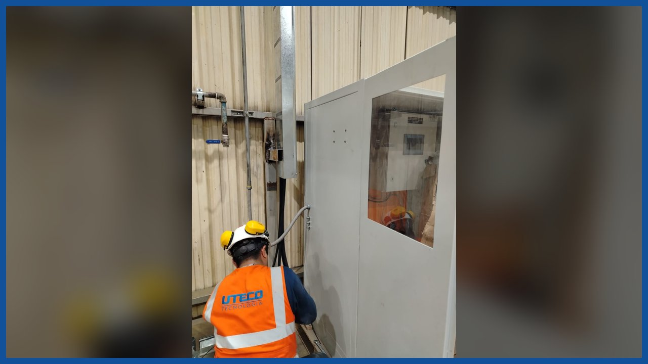 Técnico de UTECO con chaleco reflectivo operando el tablero del sistema de lubricación
